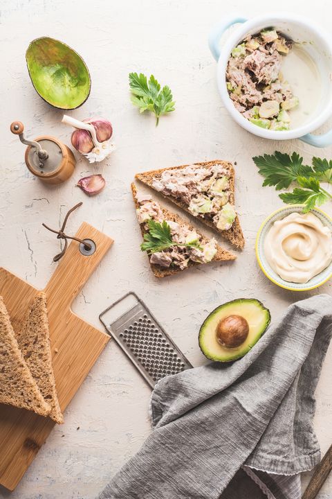 healthy snack sandwiches with tuna avocado spread on light table background, top view