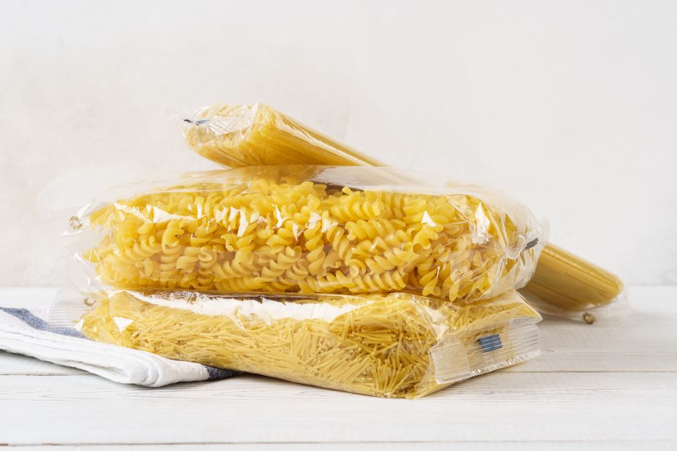 various pasta in transparent plastic bags on a kitchen table grocery goods spaghetti, fusilli and vermicelli