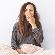 girl under bedsheets yawning from fatigue girl under bedsheets yawning from fatigue