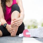 foot stress fracture test, young woman massaging her painful foot while exercising running sport and excercise injury concept