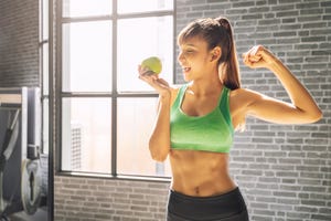 mujer fitnness sosteniendo una manzana