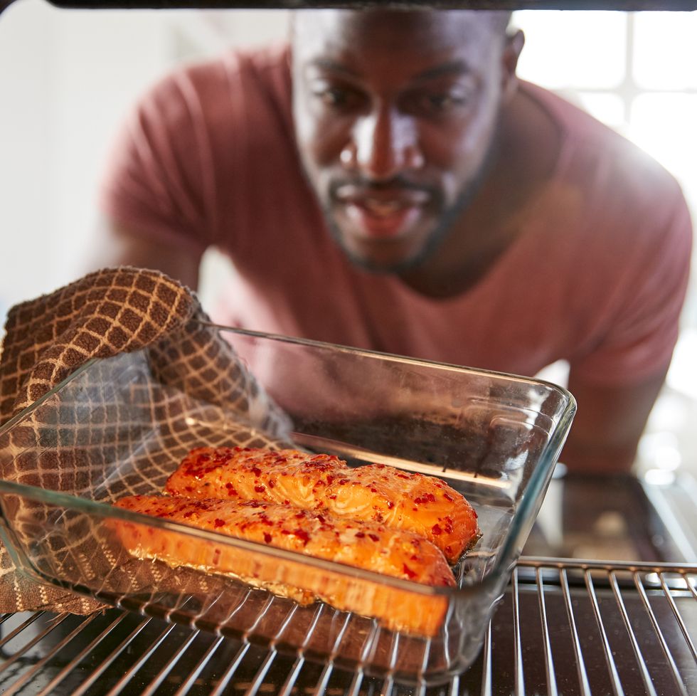 view looking out from inside oven as man cooks oven baked salmon