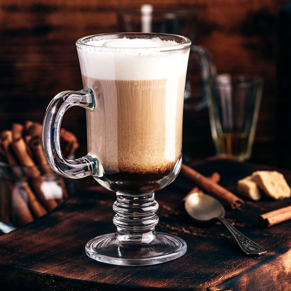 irish coffee in drinking glass on wooden surface