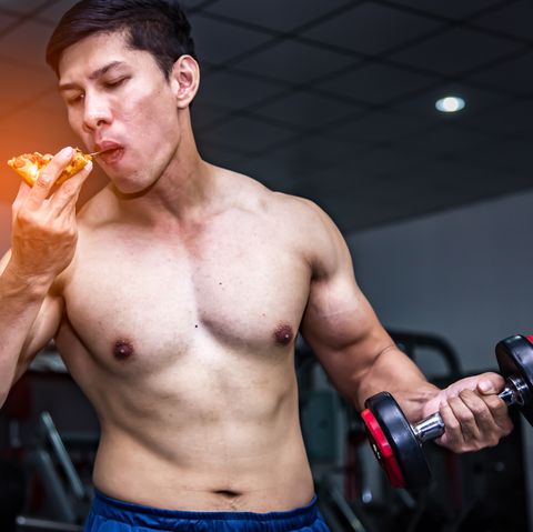 strong muscular athlete men with pizza fast food unhealthy eating diet concept