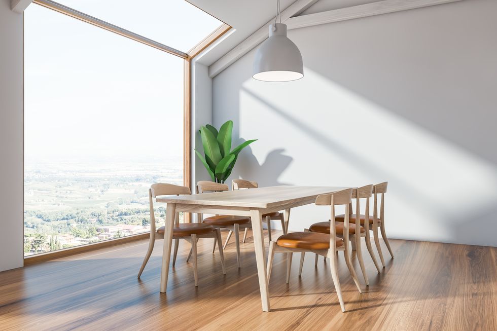scandinavian dining room interior with white walls, wooden floor, long wooden table with chairs, large window and plant in the corner 3d rendering
