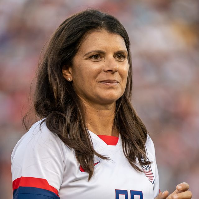 mia hamm wears a white usa team jersey and looks to the right of the camera