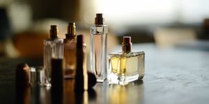 four perfume bottles anad red lipstick in a beautiful sunlight