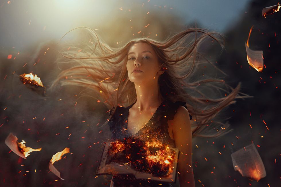 witch in fire burning pages background surrounded by burning pages