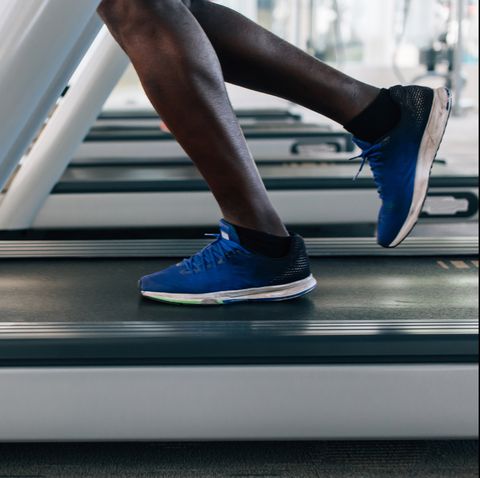 Faceless male runner running on treadmill