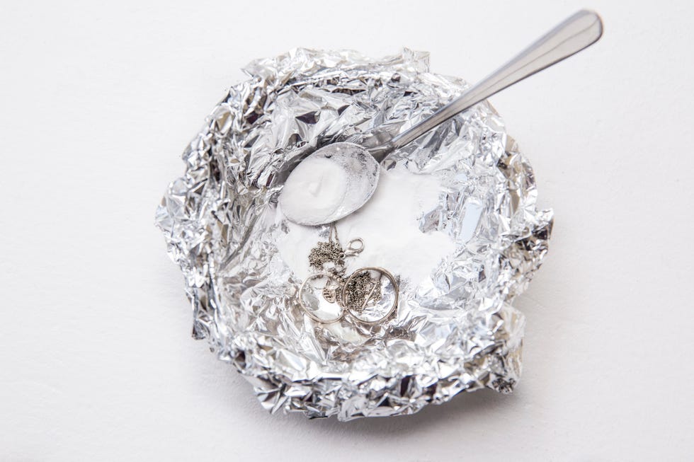 a solution of baking soda(sodium bicarbonate) and warm water will remove the tarnish from silver when the silver is in contact with a piece of aluminium tin foil. pouring hot water over silver.