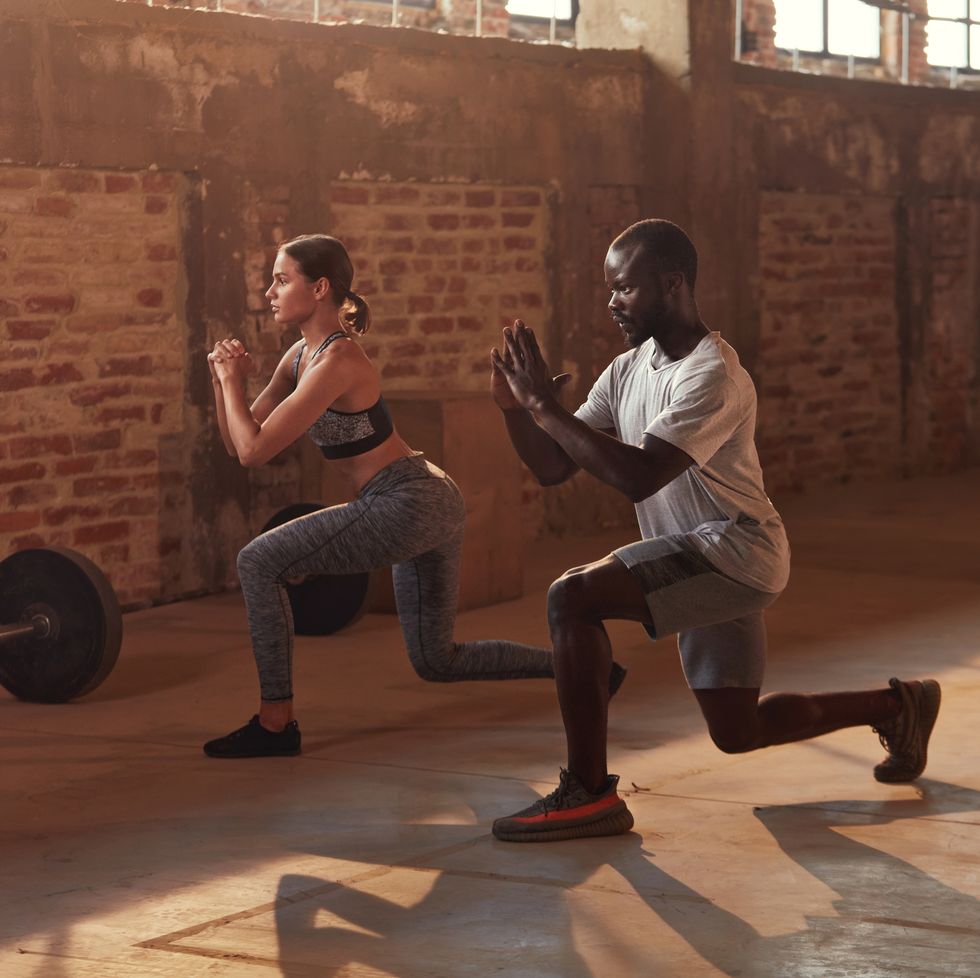 sport couple doing leg lunge exercise workout at gym fit athlete people in sports clothes exercising lunges having fitness training indoors