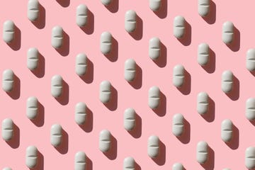 rows of white tablets on a pink background