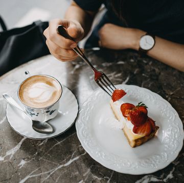 close up of young woman having a relaxing time enjoying coffee and cake in a cafe
