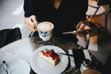 Close up of busy young businesswoman working on digital tablet in an outdoor cafe