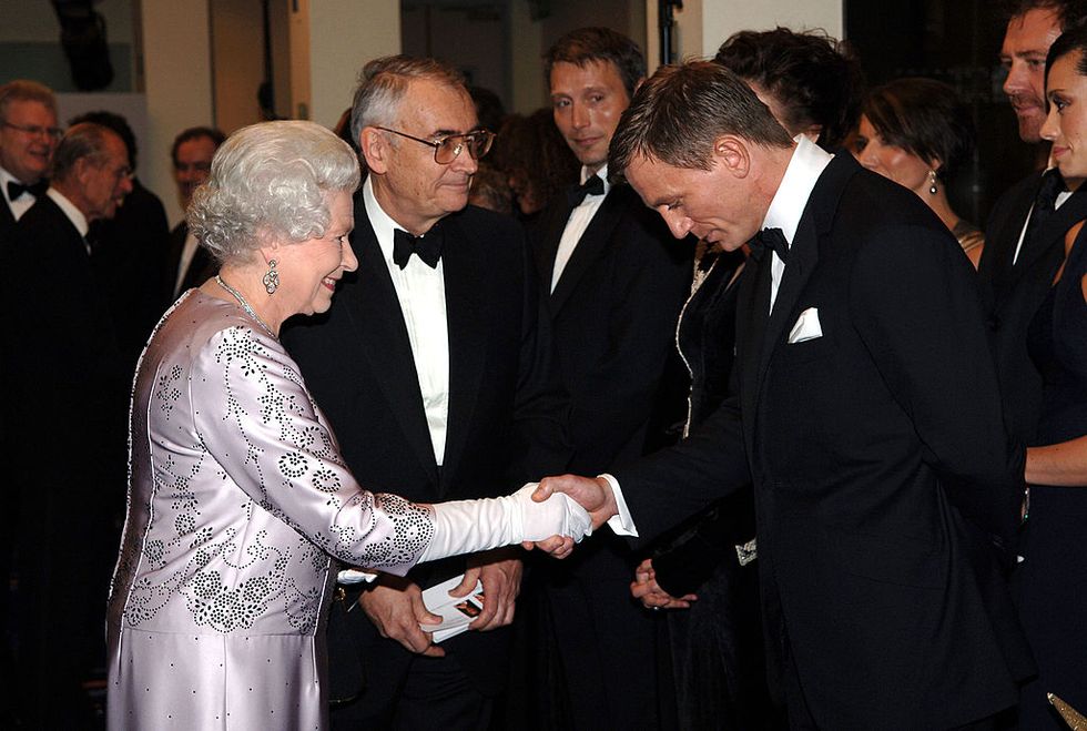 hm queen elizabeth ii shakes hands with british actor daniel craig the new james bond at the royal premiere for the 21st bond film casino royale at the odeon, leicester square on november 14, 2006 photo by anwar husseinwireimage