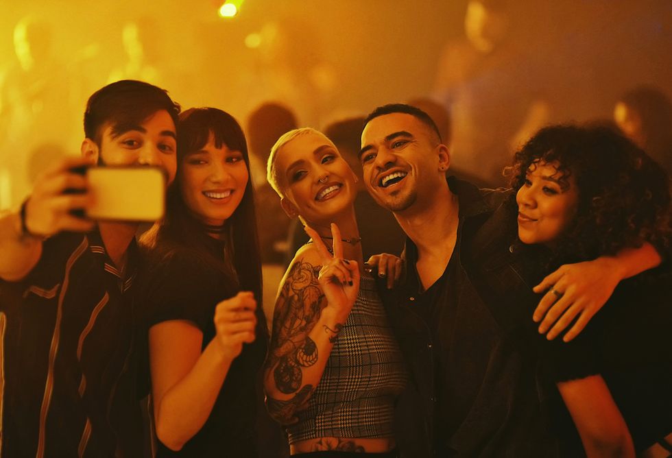 cropped shot of a diverse group of young friends taking a selfie at a party in a nightclub