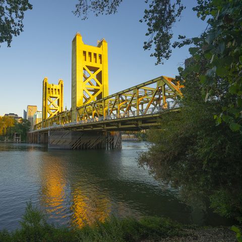 tower bridge and sacramento, california downtown skyline reflecting in sacramento river