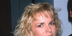 nicole brown simpson smiles at the camera, she wears a black and white patterned dress with a high collar