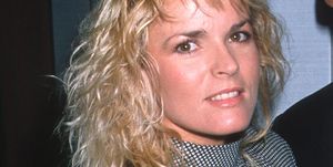 nicole brown simpson smiles at the camera, she wears a black and white patterned dress with a high collar