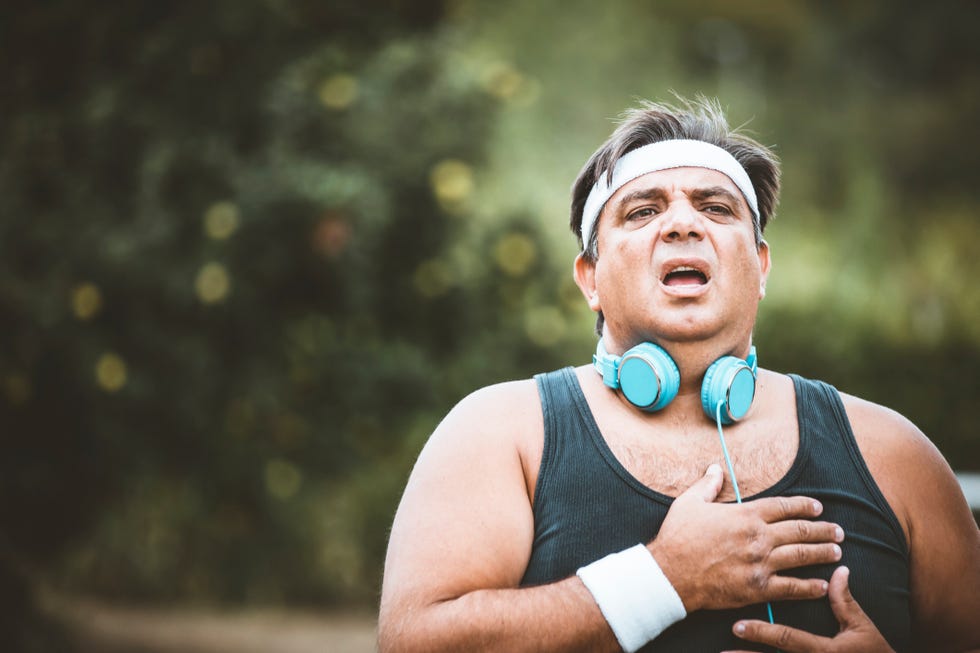 mature overweight man having heart attack or heart failure after running at park, exhausted, tired, illness or over train concept