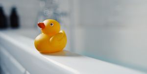 Yellow toy rubber duck on side of bath
