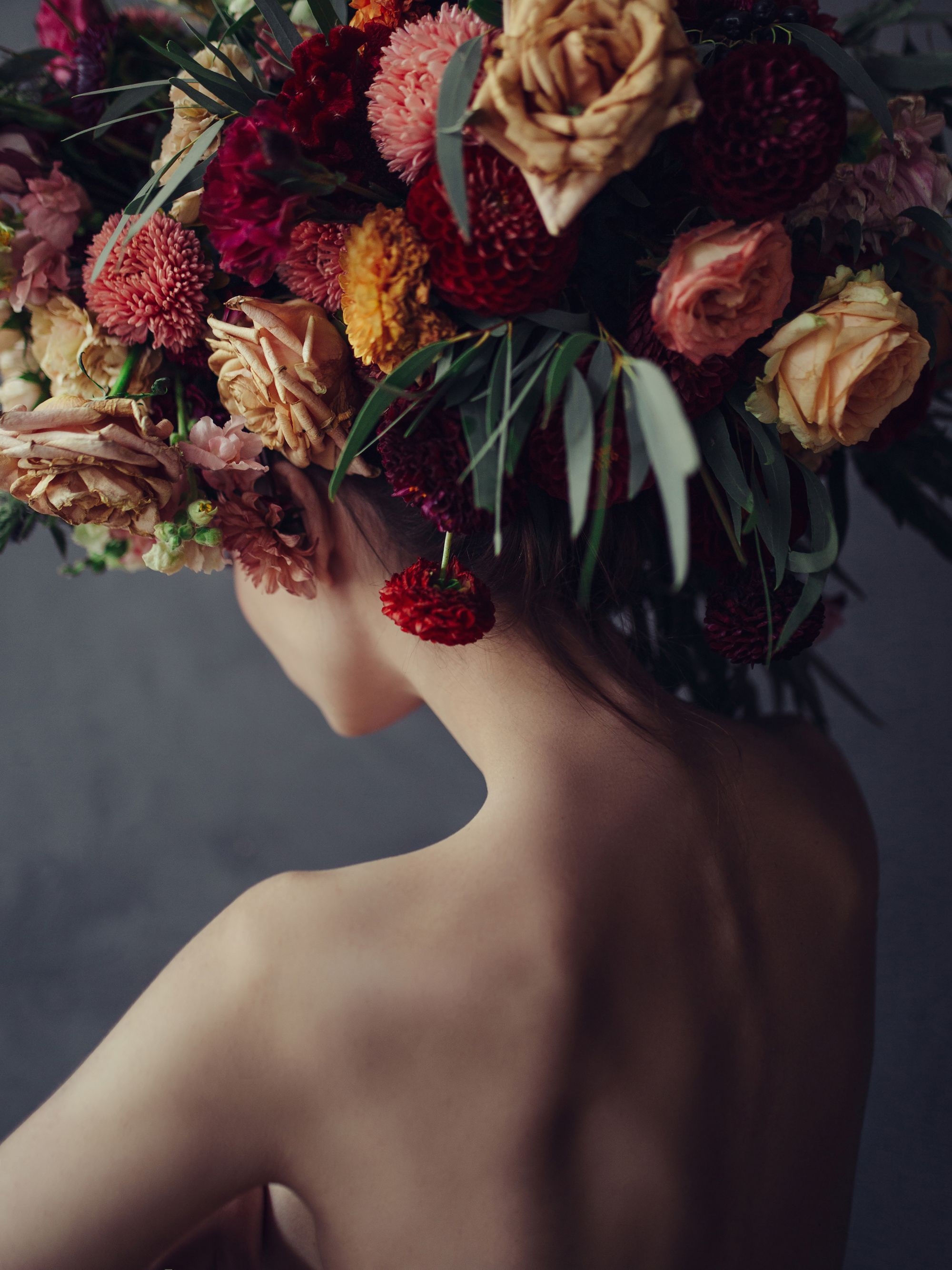 conceptual portrait of young woman wearing floral headdress