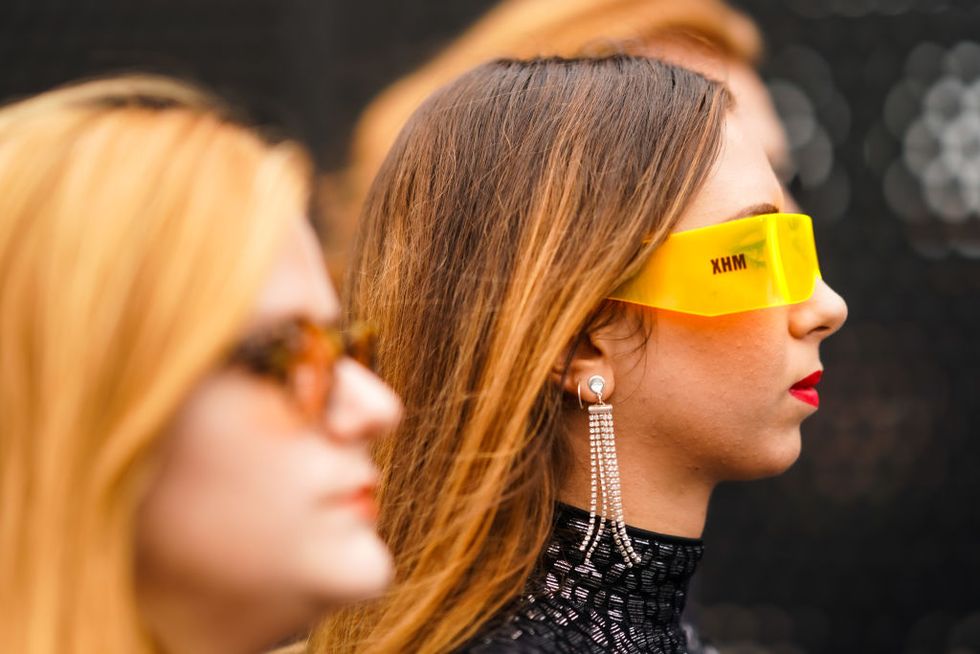 milan, italy   september 22  a guest wears earrings, yellow sunglasses, a glittering black lame hi neck top, outside the gucci show during milan fashion week springsummer 2020 on september 22, 2019 in milan, italy photo by edward berthelotgetty images