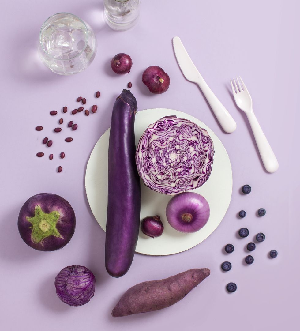 various purple colour fruits and vegetables on purple background