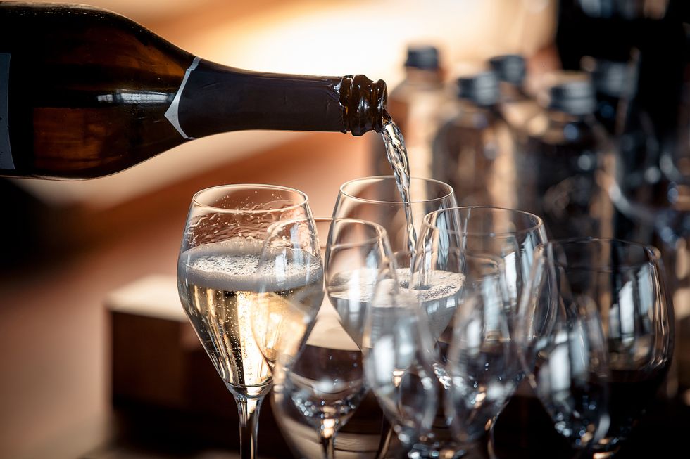 sparkling wine is poured into a glass at a party in a restaurant