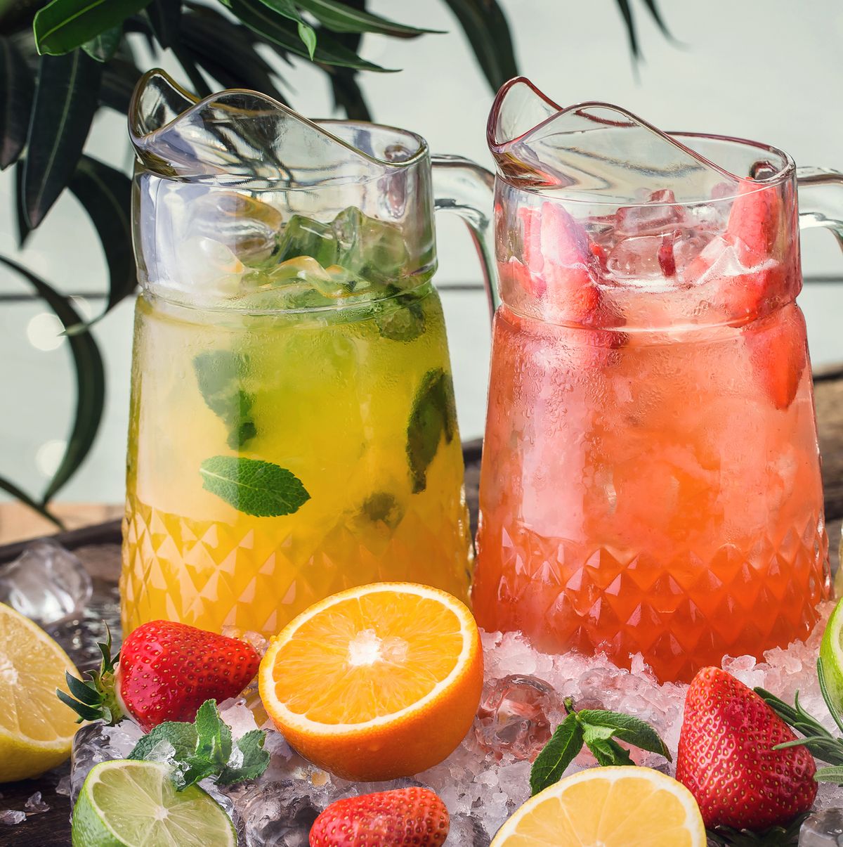 three jugs with fresh drinks from strawberry, orange and lemon juice, detox citrus water