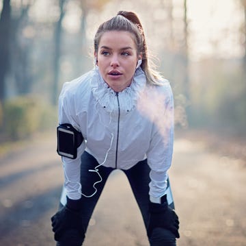 Young girl is resting exhausted after run in foggy morning