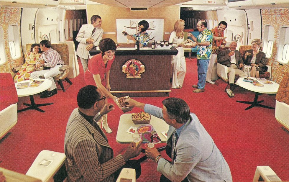 Op een vlucht van Continental Airlines bedient een stewardess passagiers in de Polynesische Pub aan boord In de jaren zeventig waren veel van de nieuwe Jumbo Jets voorzien van hippe bars Sommige passagiers dronken daar te veel waardoor het wangedrag tegenover cabinepersoneel toenam