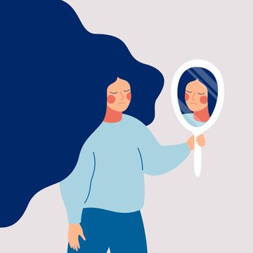 sad young woman looks on her reflection in mirror with sorrow cartoon flat style