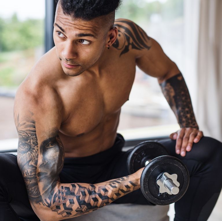 Closeup of a man with tattoos posing for a photo in the gym Stock Photo -  Alamy