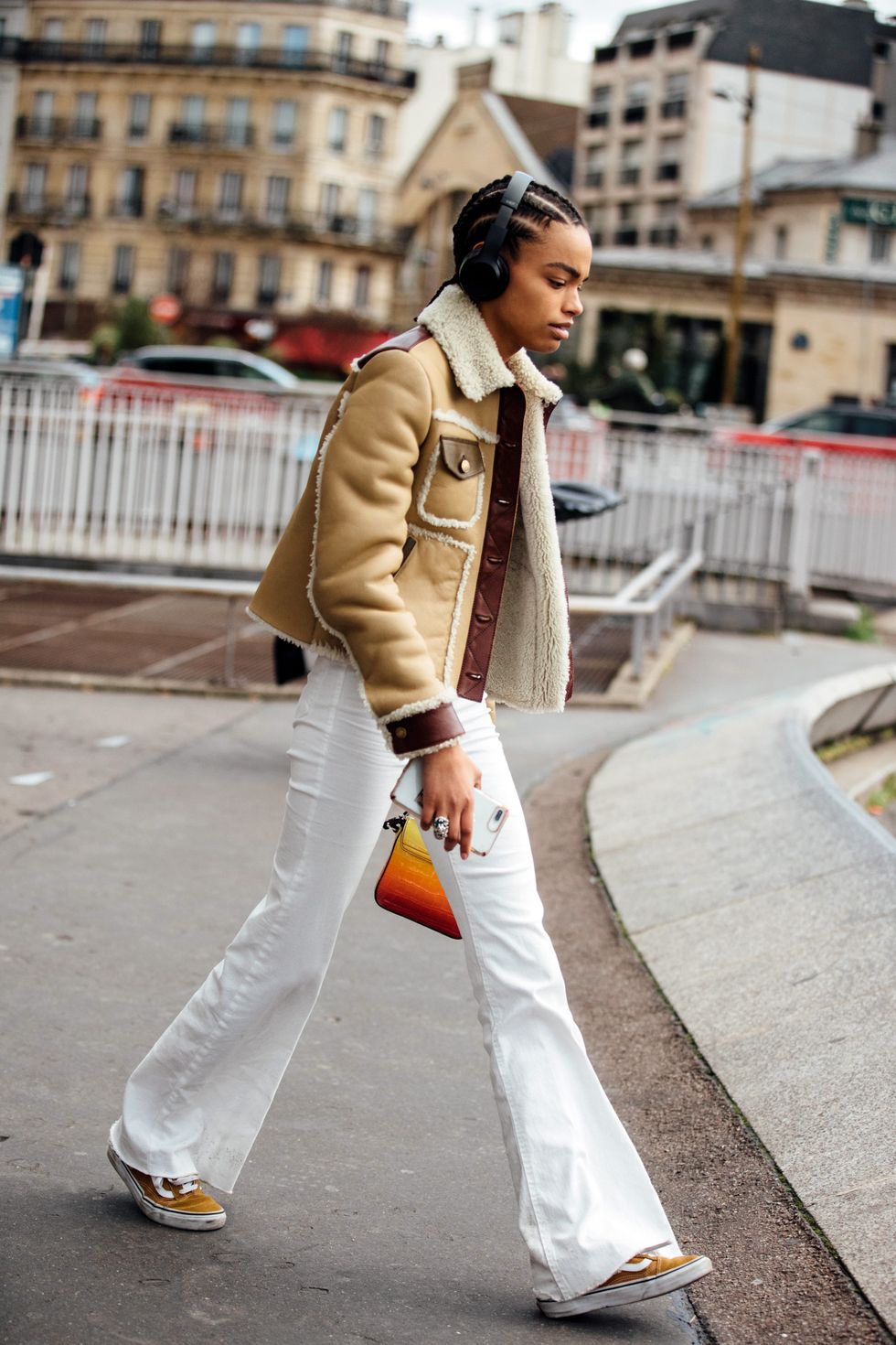 paris, france   march 04 model alexis sundman wears black headphones, a tan coach shearling jacket, white flare jeans, and yellow vans sneakers after the giambattista valli show during paris fashion week fallwinter 2019 on march 04, 2019 in paris, france photo by melodie jenggetty images