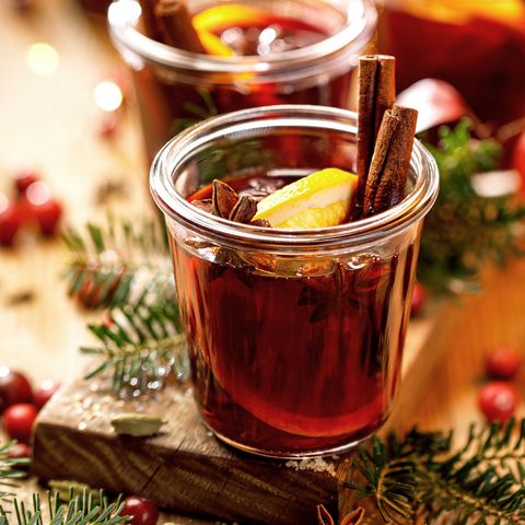christmas mulled red wine with spices and citrus fruits on a wooden rustic table, copy space traditional hot drink at christmas time