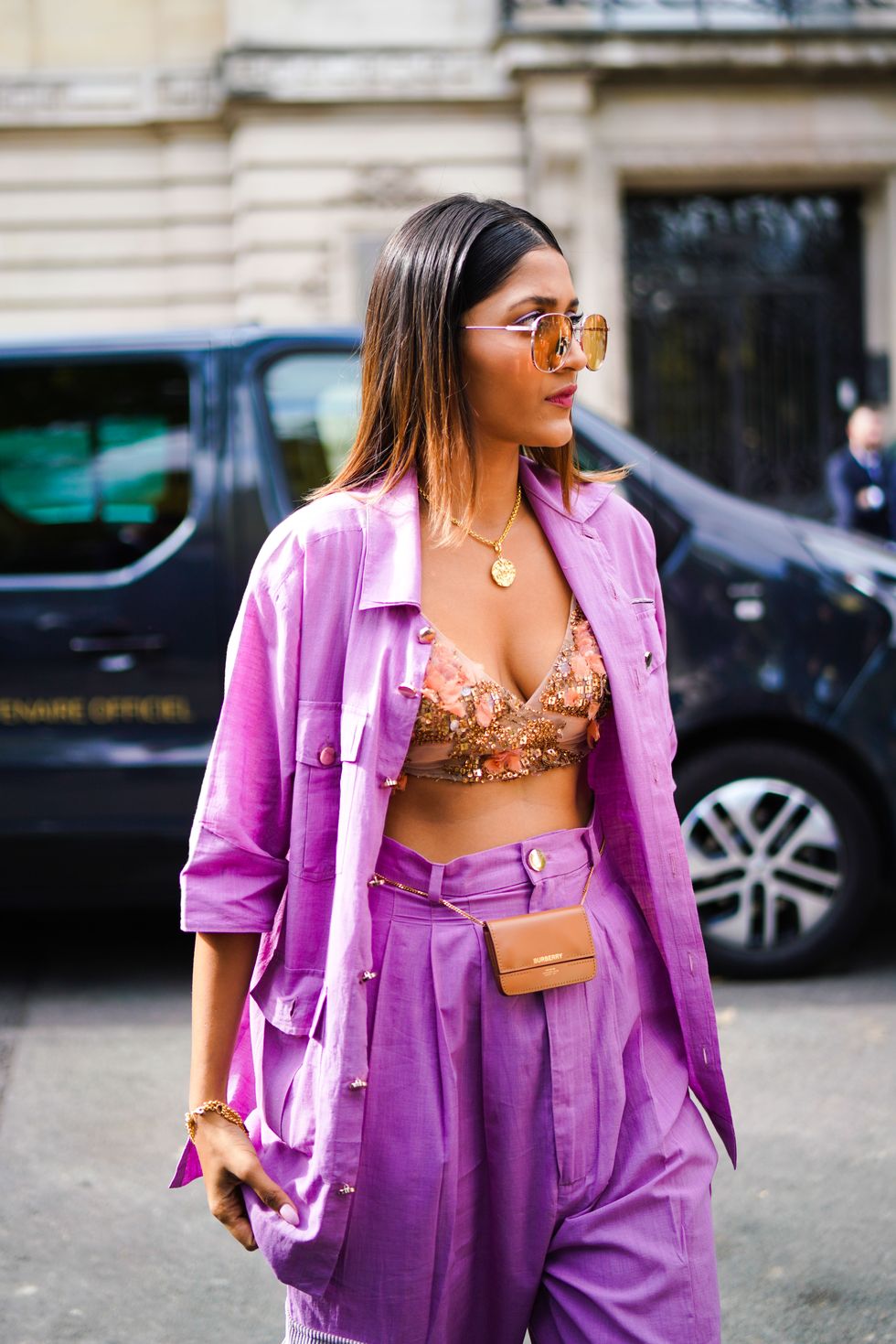 paris, france   september 28 a guest wears sunglasses, a purple opened shirt, a golden necklace, purple pants, a brown leather belt mini bag from burberry, bejewelled and floral print bras, outside elie saab, during paris fashion week   womenswear spring summer 2020, on september 28, 2019 in paris, france photo by edward berthelotgetty images