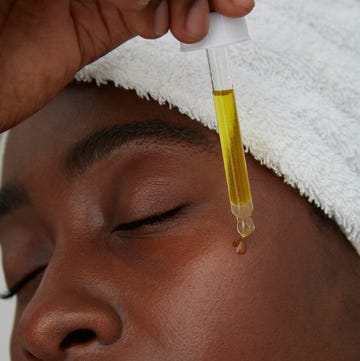 Portrait of African woman using pipette, skin care a man getting his hair done