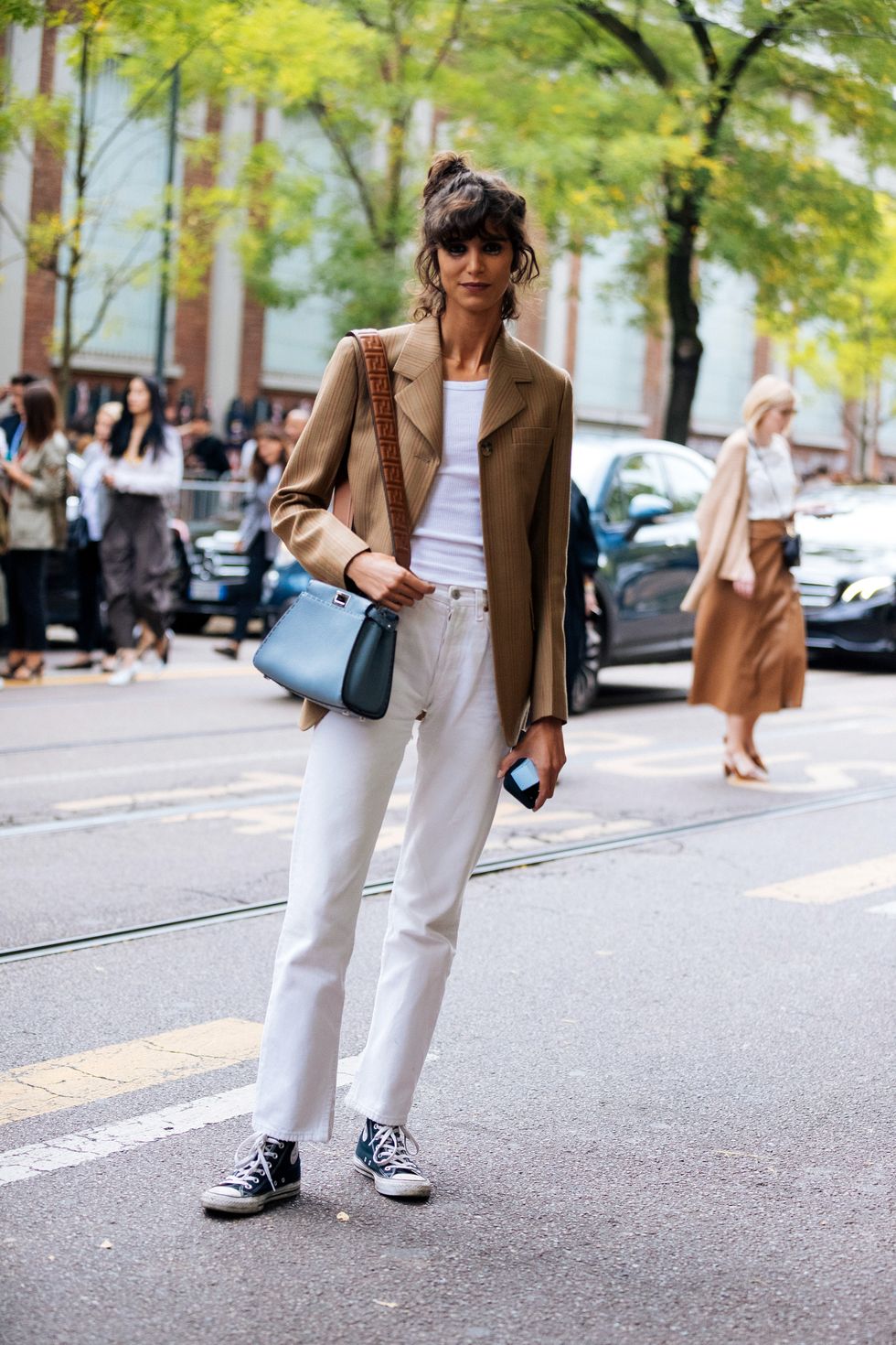 milan, italy   september 19  model mica arganaraz wears a light brown blazer, blue fendi bag, white tanktop, white jeans, and blue converse sneakers after the fendi show during milan fashion week springsummer 2020 on september 19, 2019 in milan, italy photo by melodie jenggetty images