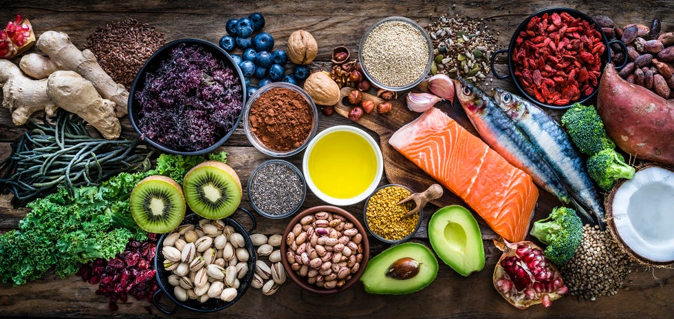 top view of healthy, antioxidant group of food shot on rustic wooden table the panoramic composition includes food rich in antioxidants considered as a super food like avocado, kale, blueberries, chia seeds, coconut, broccoli, different nuts, salmon, sardines, pollen, quinoa, hemp seeds, seaweed, cocoa, olive oil, goji berries, flax seeds, kiwi fruit, pomegranate and ginger xxxl 42mp studio photo taken with sony a7rii and zeiss batis 40mm f20 cf