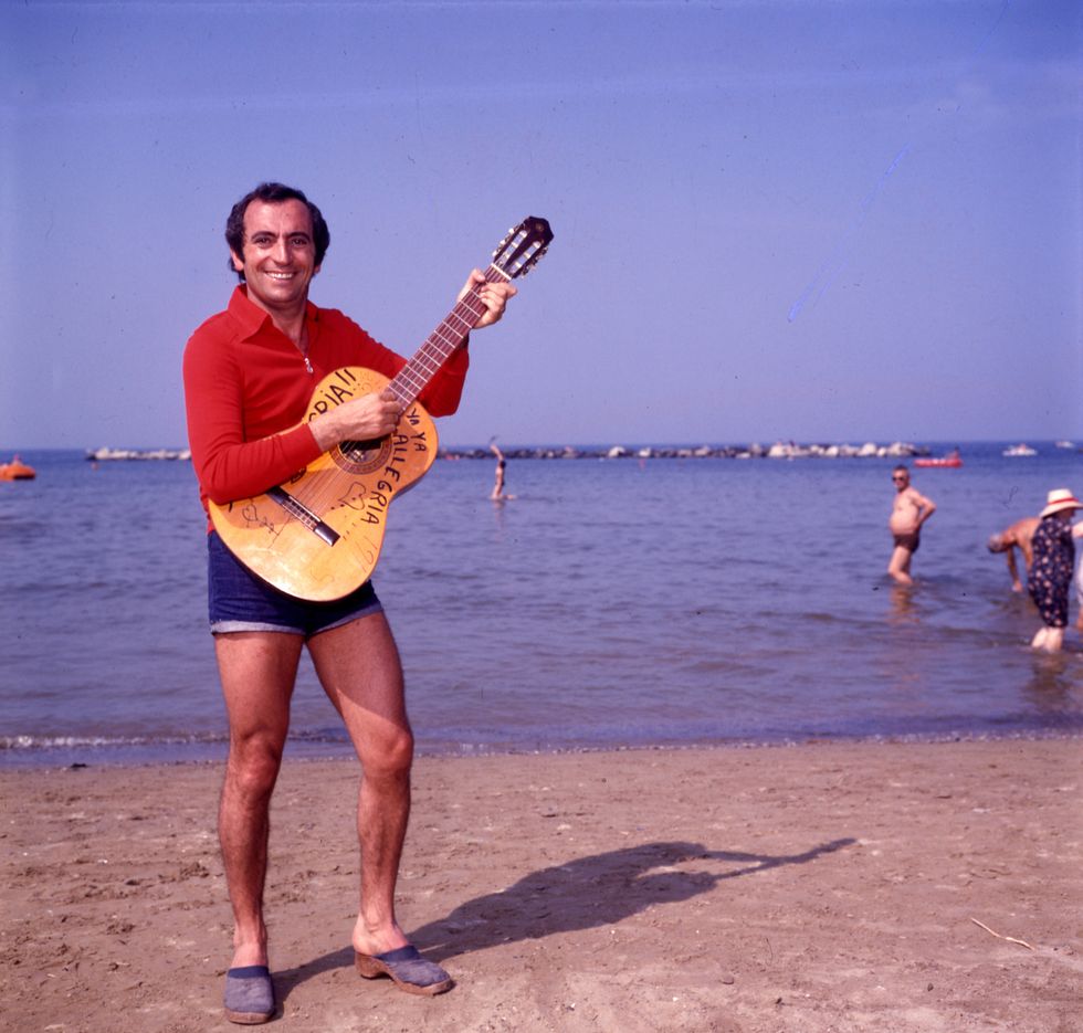 raoul casadei plays his guitar at adriatico beach italy, 70's  photo by egizio fabbricimondadori portfolio via getty images