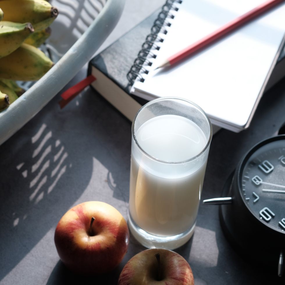top view of fruit, milk and clock