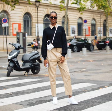 a person in a suit and sunglasses standing in a crosswalk