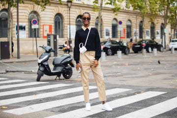 a person in a suit and sunglasses standing in a crosswalk