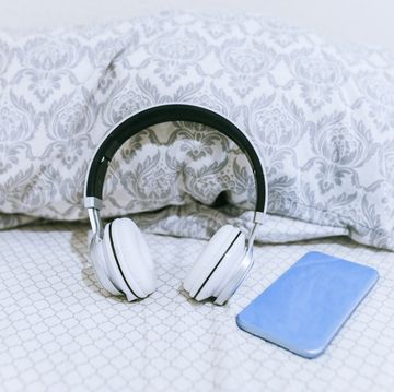 mobile phone and headphones on the bed