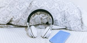 mobile phone and headphones on the bed