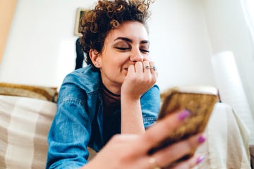 young woman, with short, curly hair, using phone