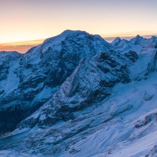 aerial panoramic of the stelvio pass ski area and snowy ortles mount at dawn, sondrio province, valtellina, lombardy, italy