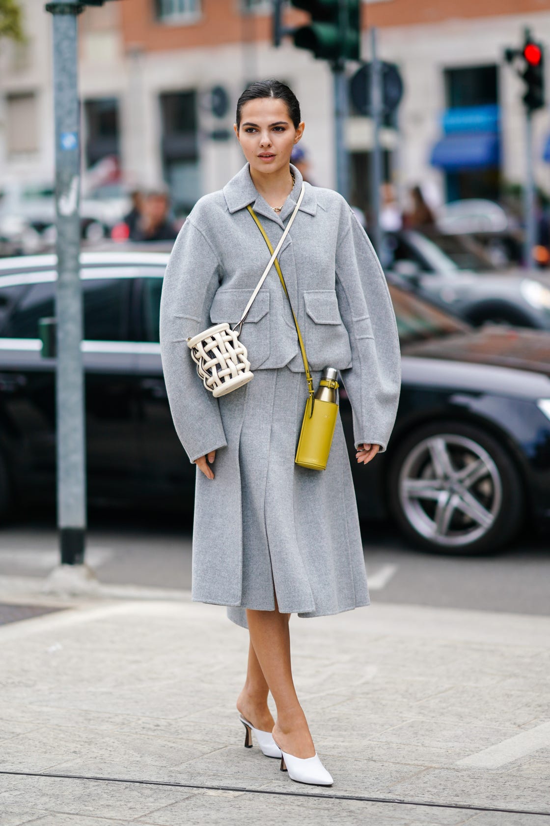 milan, italy september 20 doina ciobanu wears a light grey wool oversized jacket, a light grey split skirt, a white woven leather openwork cylindric bag, a yellow leather bottle holder, white pointy mules, outside the sportmax show during milan fashion week springsummer 2020 on september 20, 2019 in milan, italy photo by edward berthelotgetty images