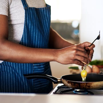 cropped shot of an unrecognizable man frying eggs while making breakfast in his kitchen at home